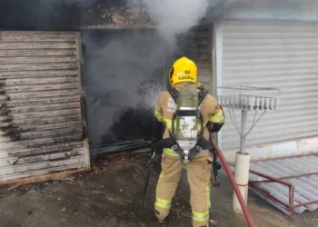 Carro pega fogo em garagem e idoso é resgato da residência em Poços
